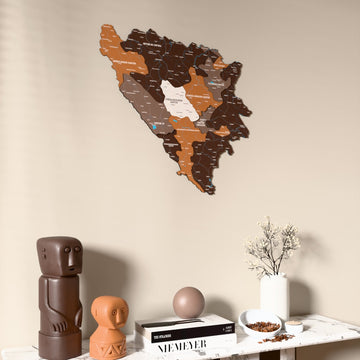 Soil Bosnia and Herzegovina wooden wall map on a beige wall above a console with figurines