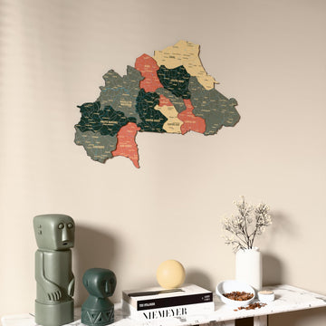 Sage Burkina Faso wooden wall map on a beige wall above a console with figurines