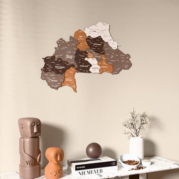 Soil Burkina Faso wooden wall map on a beige wall above a console with figurines