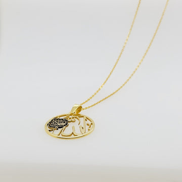 Circular gold Allah pendant laid at an angle with its chain trailing across a white surface