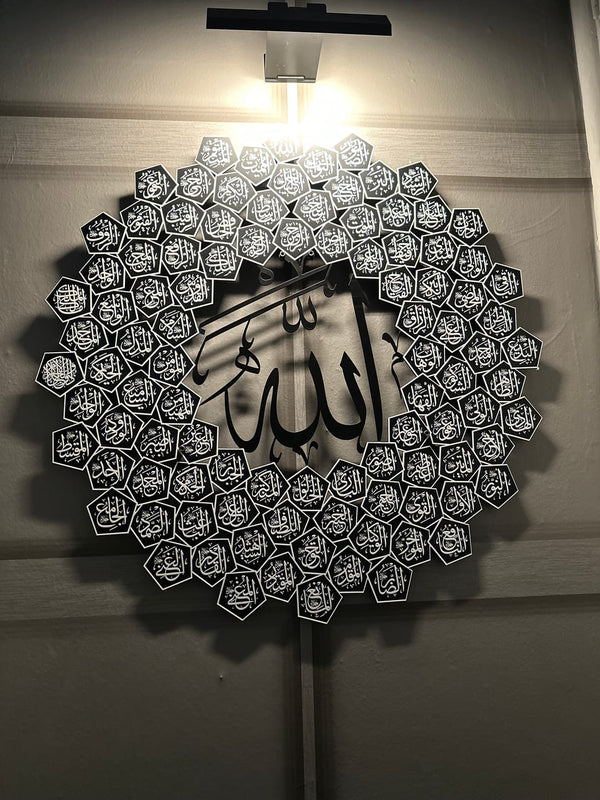 Customer photo of a round 99 Names of Allah metal wall art lit by a wall lamp