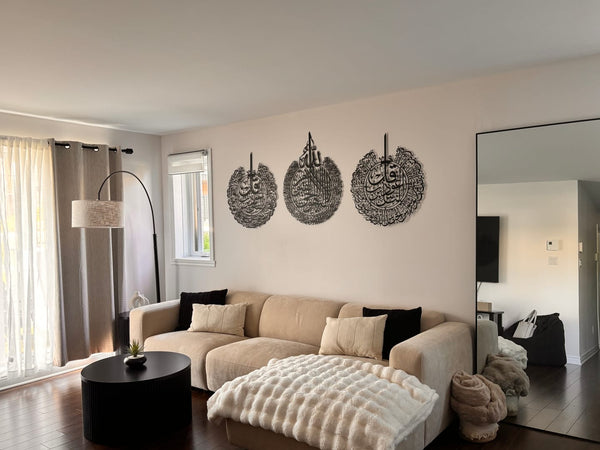 Customer photo of three round black calligraphy wall art pieces above a beige sofa