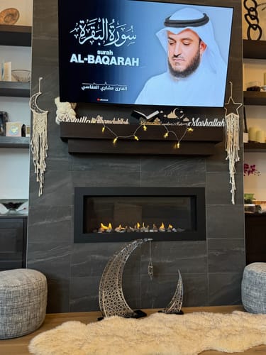 Customer photo of a crescent moon decor in front of a fireplace below a TV