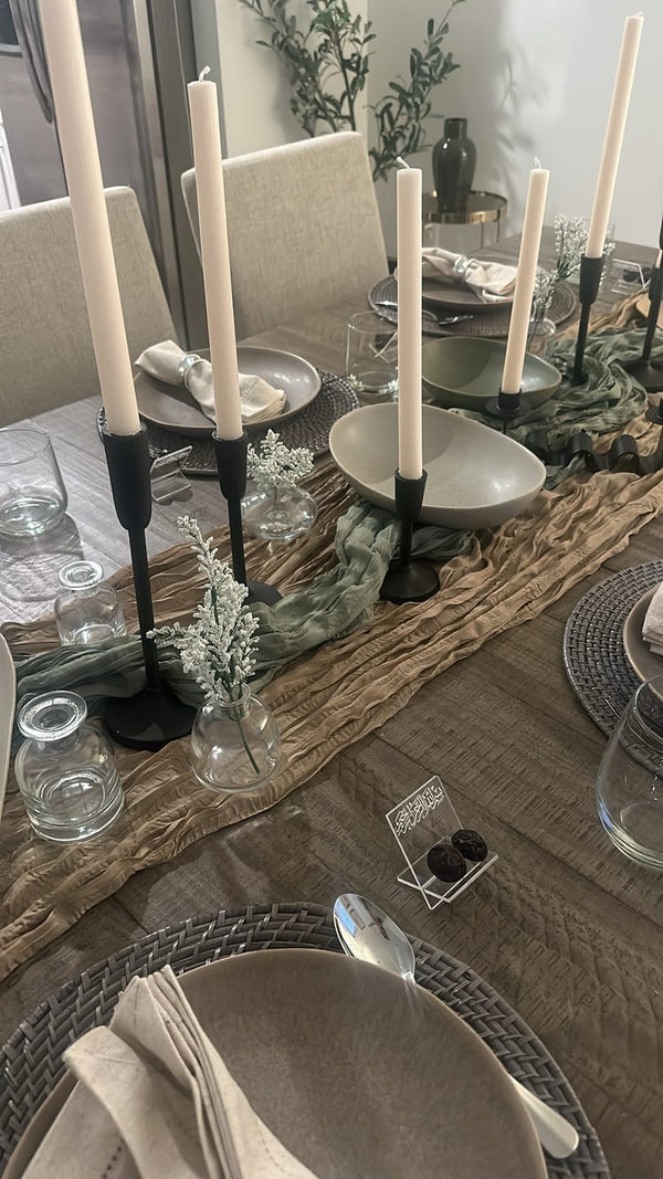 Customer photo of a dining table set with black candlesticks and a wooden runner