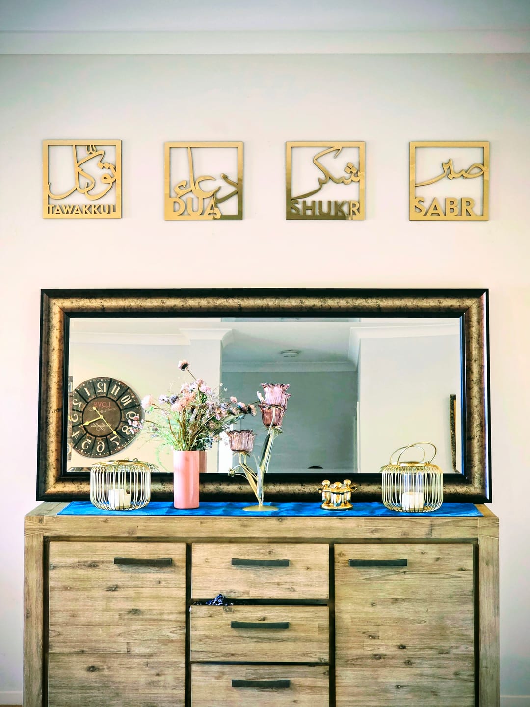 Customer photo of four small gold dhikr panels above a mirror and wooden dresser