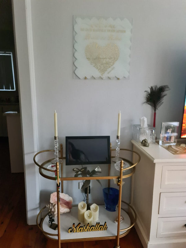 Customer photo of a gold Mashallah sign on a bar cart below framed calligraphy