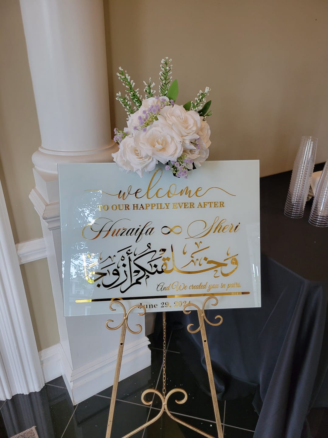 Kundenfoto: verspiegeltes Nikah-Willkommensschild mit Blumen auf einer goldenen Staffelei