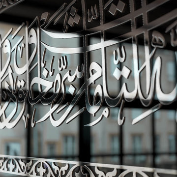 Très gros plan sur les lettres arabes et la bordure en acrylique argenté sur le verre noir du dua de protection