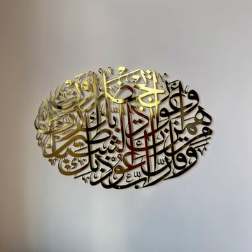 لوحة جدارية معدنية بيضاوية ذهبية لامعة بدعاء الحماية من الشر، سورة المؤمنون 97-98، منظر أمامي على جدار فاتح