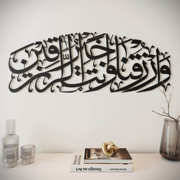 Art mural en métal noir Dua pour le rizq, vue de face avec une branche et un vase à droite