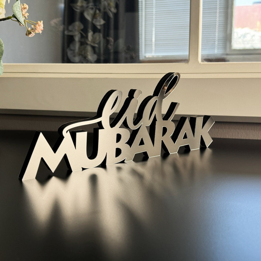 ديكور طاولة فضي «عيد مبارك» أمام نافذة بستائر، منظر مائل