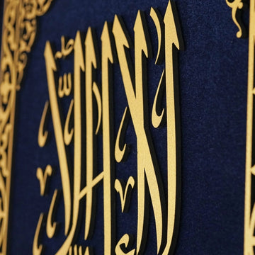 لقطة مقربة لحروف كلمة التوحيد الأولى الذهبية البارزة على مخمل أزرق
