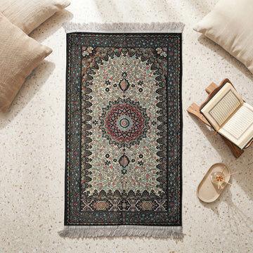 Floral Vine Prayer Rug in Anthracite - Cream, top view on the floor next to a Quran stand and cushions