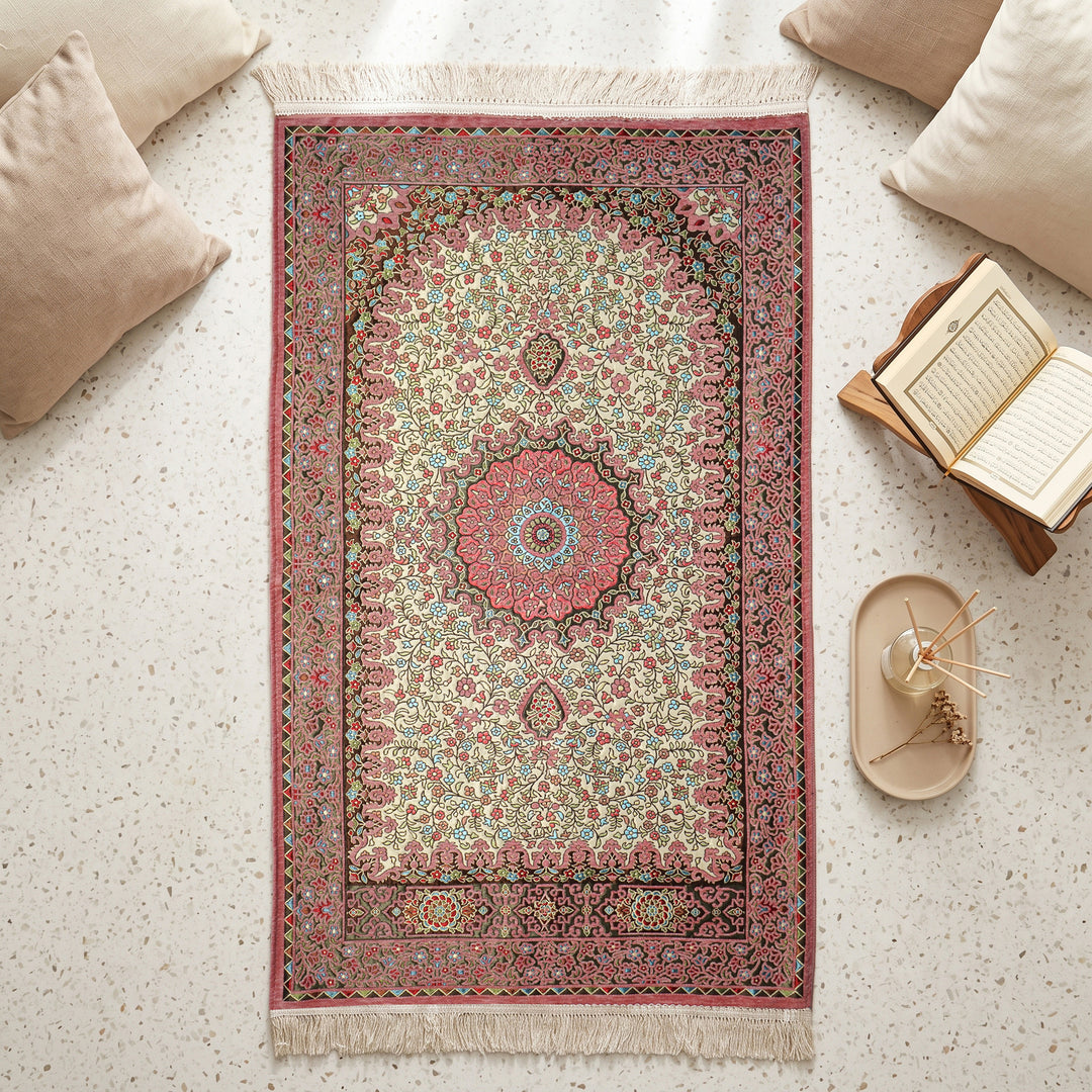 Floral Vine Prayer Rug in Dried Rose - Cream, top view on the floor next to a Quran stand and cushions