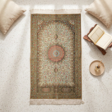 Floral Vine Prayer Rug in Mink - Cream, top view on the floor next to a Quran stand and cushions