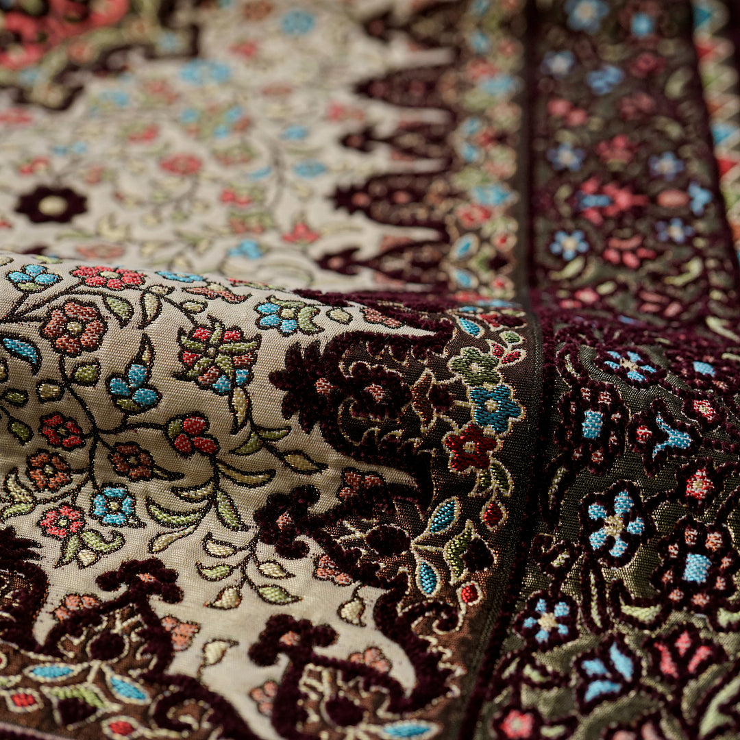 Floral Vine Prayer Rug in Plum - Cream: close-up of the pattern on the folded rug
