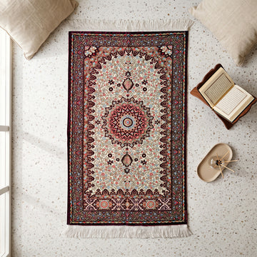 Floral Vine Prayer Rug in Plum - Cream, top view on the floor next to a Quran stand and cushions
