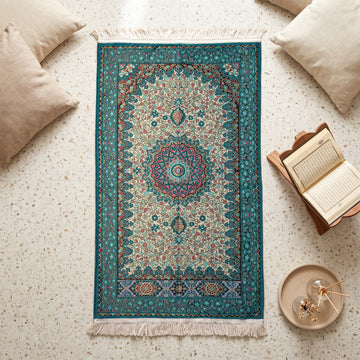 Floral Vine Prayer Rug in Turquoise - Cream, top view on the floor next to a Quran stand and cushions