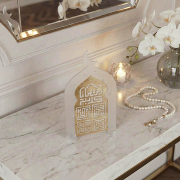 Schräge Ansicht des Kufi-Ramadan-Kareem-Acrylaufstellers in Gold auf Frostweiß mit Gebetskette
