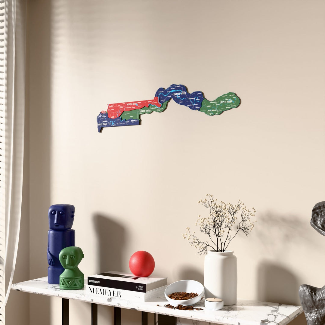 Flag colored Gambia wooden wall map beside a sheer curtain, angled view