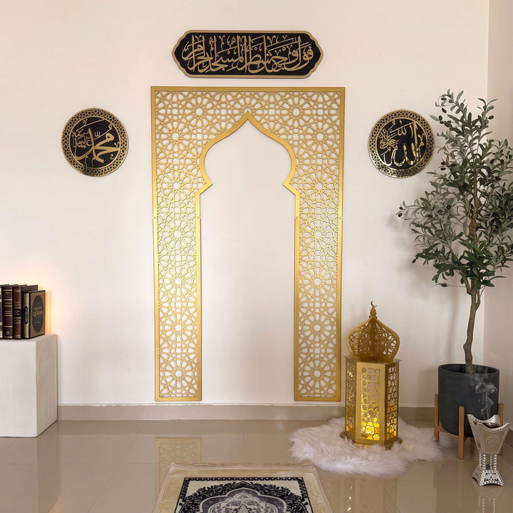 Goldener Metall-Mihrab mit Allah- und Muhammad-Kalligrafie und Tafel mit Sure Al-Baqara 2:144 in einer Gebetsecke
