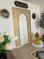 Gold lattice mihrab panel framing a prayer corner with a lantern and rug