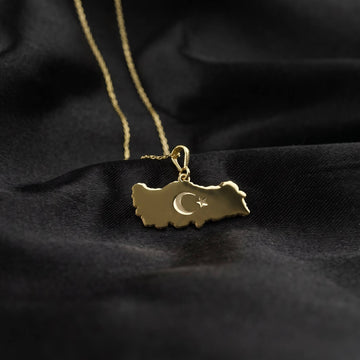 Gold Turkiye map pendant on black satin, smaller view with a long chain