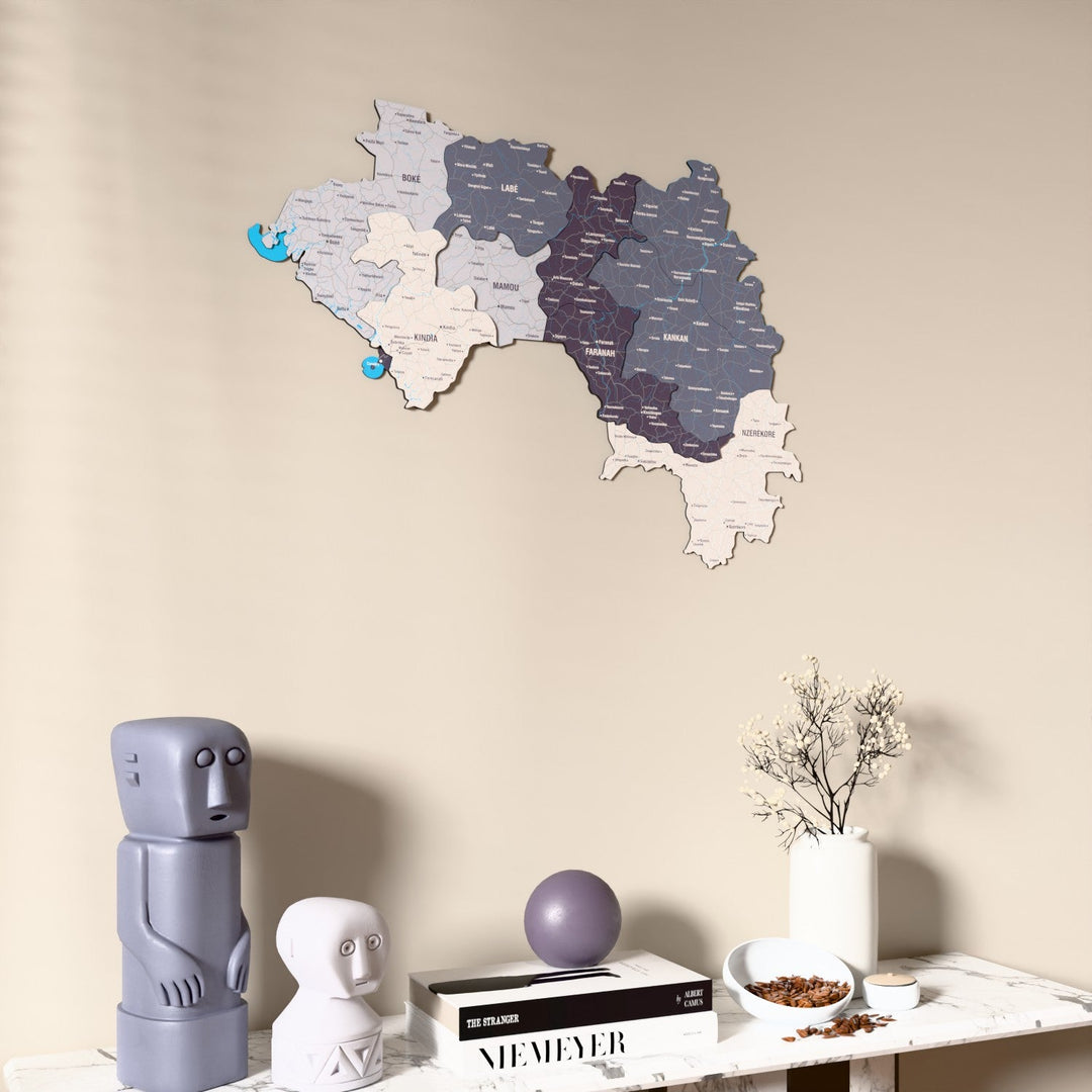 Nimbus Guinea wooden wall map on a beige wall above a console with figurines