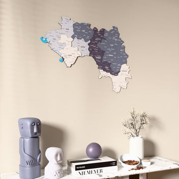 Nimbus Guinea wooden wall map on a beige wall above a console with figurines
