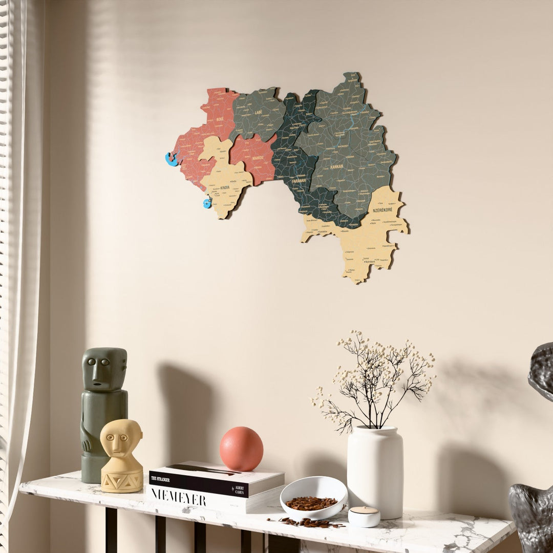 Sage Guinea wooden wall map beside a sheer curtain, angled view
