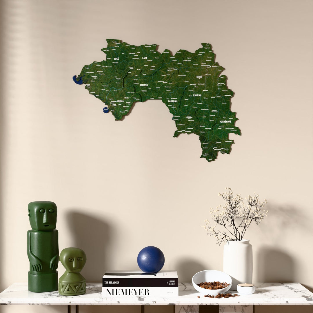Satellite Guinea wooden wall map above a marble console, front view