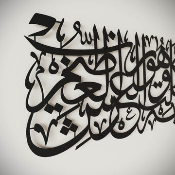 Black laser-cut Arabic calligraphy wall art mounted on a light gray wall.