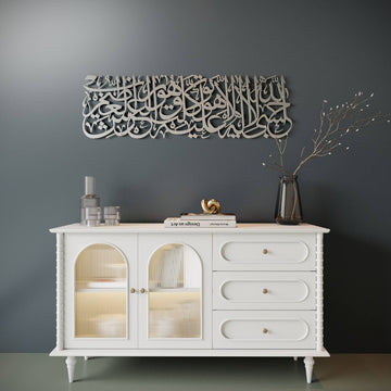 A white wooden sideboard cabinet with two arched glass-front doors and three drawers, styled against a dark gray wall with decorative wall art and small tabletop objects.