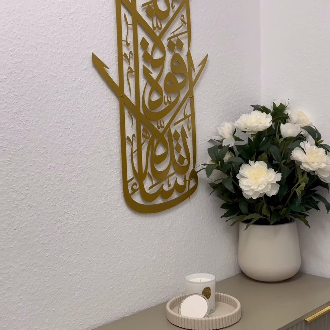 Art mural calligraphique arabe doré vertical à côté de fleurs blanches