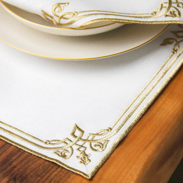 Corner of the Gold interlocking scroll border placemat under a plate on a wooden table