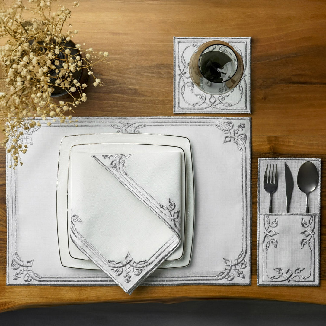 Silver interlocking scroll dining set place setting with stacked square plates, napkin and pouch, overhead