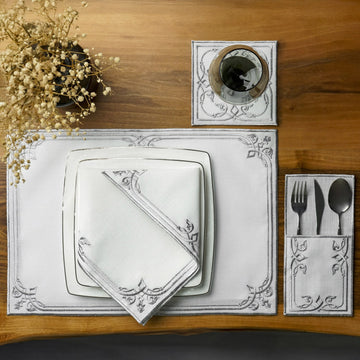 Silver interlocking scroll dining set place setting with stacked square plates, napkin and pouch, overhead