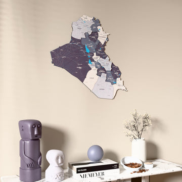 Nimbus Iraq wooden wall map on a beige wall above a console with figurines