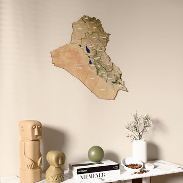 Satellite Iraq wooden wall map on a beige wall above a console with figurines