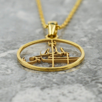 Close-up of the gold Allahu Akbar pendant, showing the cut-out calligraphy inside the ring