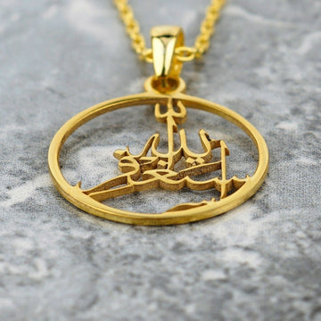 Close-up of the gold Astaghfirullah pendant, showing the raised cut-out calligraphy inside the ring