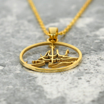 Close-up of the gold Hasbiyallah pendant, showing the raised cut-out calligraphy inside the ring