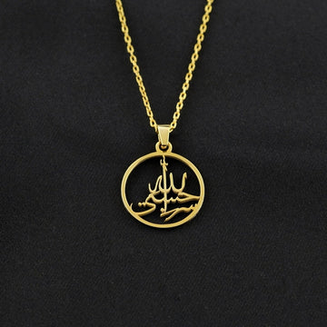 Gold Hasbiyallah Islamic necklace with a round calligraphy pendant on black fabric