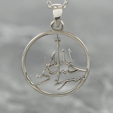 Close-up of the silver Hasbiyallah pendant, showing the cut-out calligraphy inside the ring