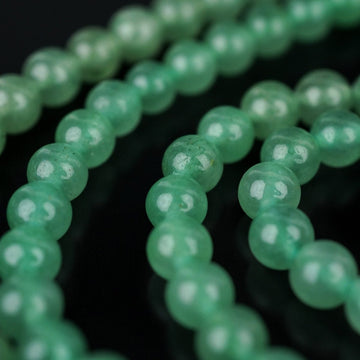 Close-up of green aventurine quartz prayer beads in two strands, showing the smooth stone surface