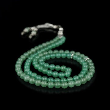 Aventurine quartz prayer beads coiled in a double loop with a silver-tone tassel on black