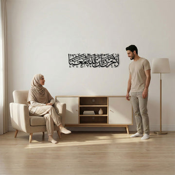 لوحة جدارية معدنية سوداء «لا تحزن إن الله معنا» على جدار غرفة المعيشة بجانب كرسي بذراعين