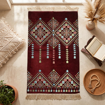 Kilim Prayer Rug in Burgundy, top view on the floor next to a Quran stand and cushions