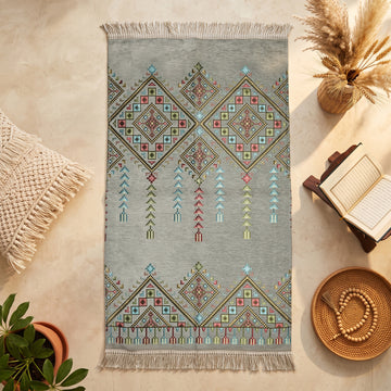 Kilim Prayer Rug in Gray, top view on the floor next to a Quran stand and cushions
