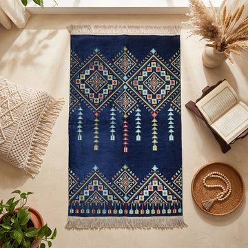 Kilim Prayer Rug in Navy, top view on the floor next to a Quran stand and cushions